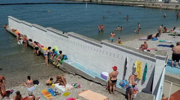 Bărbații și femeile fac plajă despărțiți de un zid înalt de trei metri la Trieste